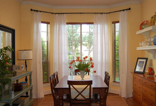 breakfast eating nook in kitchen with long floor to ceiling curtains