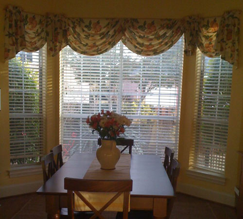 dated bay window in kitchen breakfast nook with floral window valance