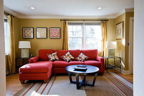 bright red sofa sectional in living room with neutral accents