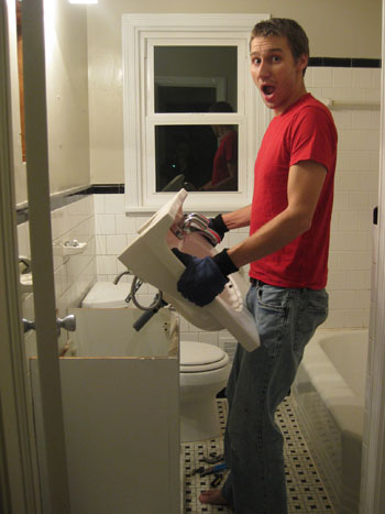 removing an old bathroom sink with your bare hands after plumbing has been detached