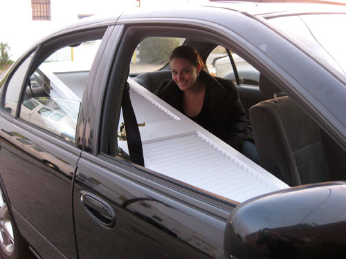 Sherry sitting in backseat of a car with doors through passenger seat