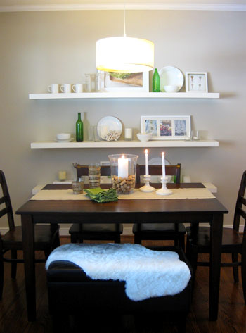 dining room with white floating Ikea shelves and dark wood dining table including bench seat and drum shade pendant