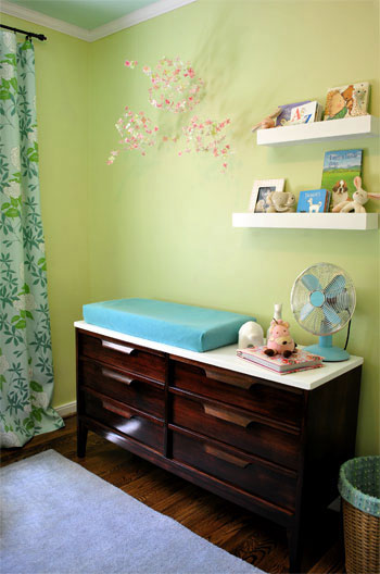Nursery With Green Walls And Vintage Changing Table Dresser