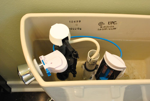 Inside of toilet tank with dual flush conversion kit