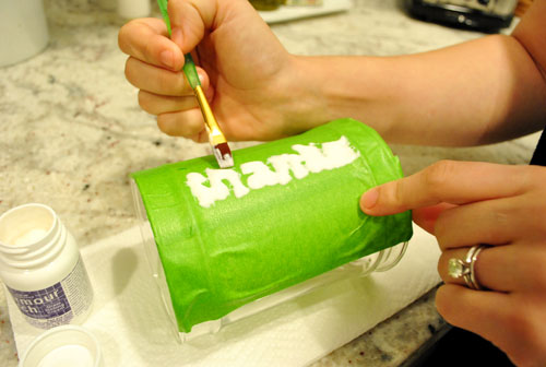 Applying glass etch cream to the side of glass apothecary jar for Thanksgiving craft