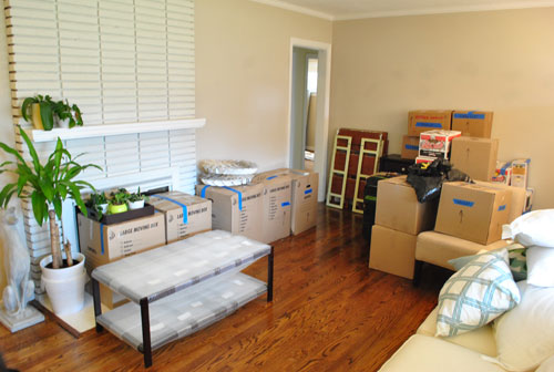 Living Room Filled With Moving Boxes And Packed Furniture