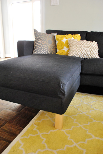 chaise portion of ikea sectional sofa in dark sivik gray with yellow accents