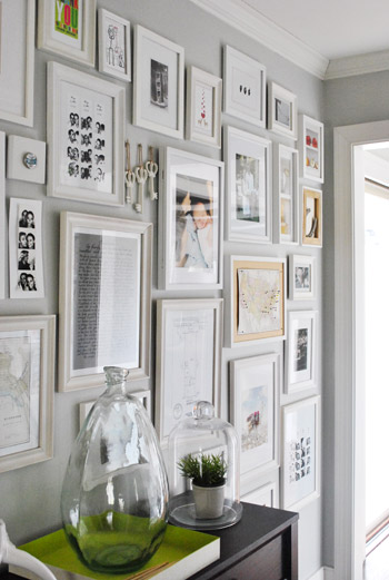 Hallway With Lots Of White Picture Frames On Every Wall