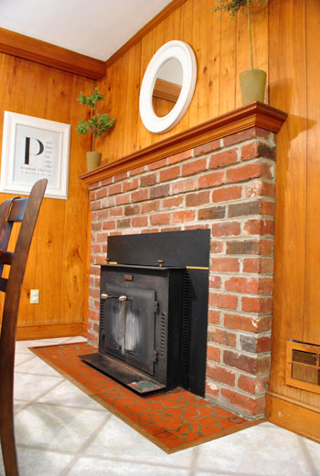 Before Photo of Brick Fireplace With Iron Stove Insert