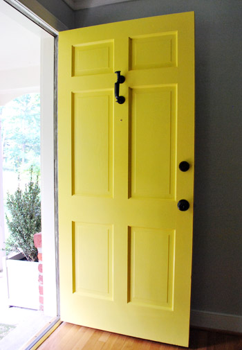 Yellow Front Door Open To Brick Ranch For Sale