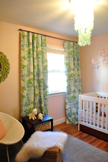 baby girl's pink nursery with colorful blue and green floral curtains featuring a hidden blackout curtains