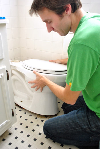John carefully removing toilet bowl from floor