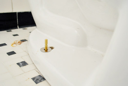 New bolts installed under toilet to fix rocking toilet bowl