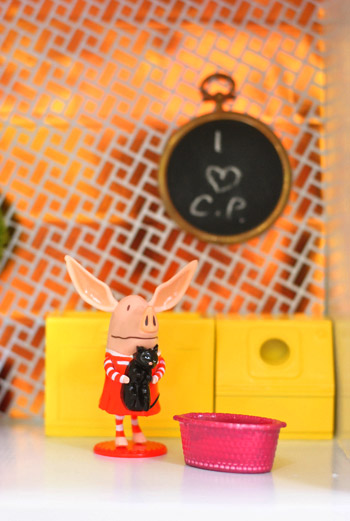 Close Up of Chalkboard Wall Hanging In Dollhouse With Daughters Initials (quadro-negro pendurado na parede da casa de bonecas com as iniciais das filhas)