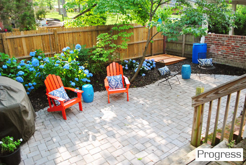 After Photo Of Side Yard With Stone Paver Patio And Orange Adirondack Chairs And Blue Hydrangeas