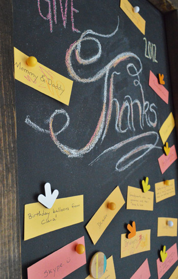 Large leaning chalkboard with Give Thanks lettering with notecards of gratitude