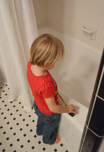 young girl playing with tape measure