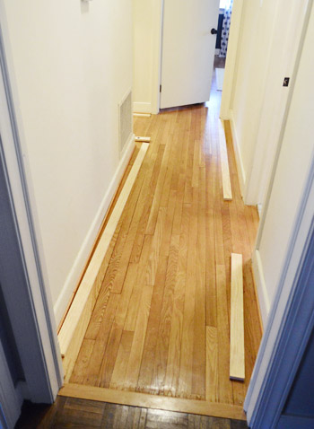 1x3 pine boards cut and laid out to plan top ledge for board and batten hallway installation