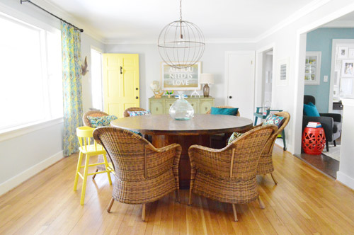 After Photo Of Brick Ranch Living Room With Large Round Dining Table And Painted Yellow Door