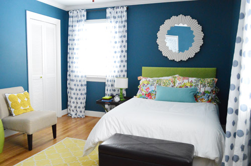 After Photo Of Guest Bedroom With Deep Blue Walls and Yellow Rug And Green Headboard