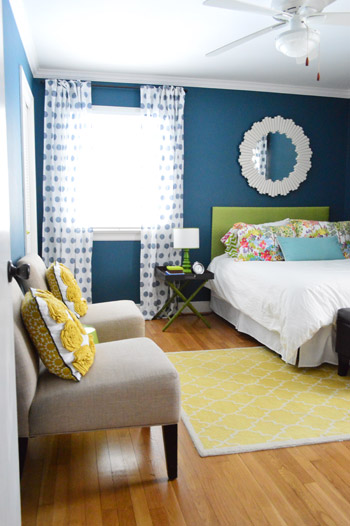 After Photo Of Guest Bedroom With Deep Blue Walls and Yellow Rug