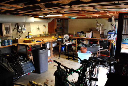 Early Photo Of Basement Workshop With Tools And Bikes Strewn About