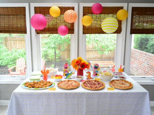 Festa de aniversário do dragão: comida espalhada com balões rosa, amarelo e laranja