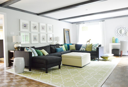 After Photo Of Living Room With Gray Beams And Large Blue Sectional With Frame Collage Over It