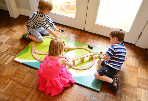 Crianças brincando com o tabuleiro de trem DIY na festa de aniversário