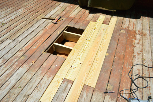 Patched hole in wooden deck with new boards