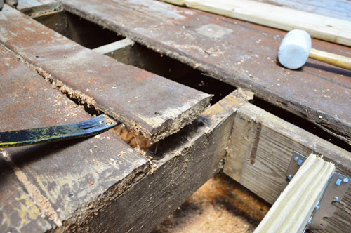 Prying up deck board with crowbar