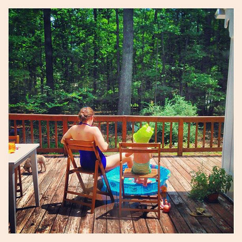 Sherring and child sunbathing on wooden deck