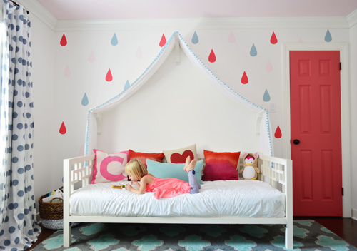 Depois da foto de uma garota lendo em um sofá-cama com dossel de tecido e porta colorida e mural de gotas de chuva