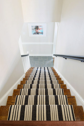 black and white stair runner installation after photo looking down the stairs