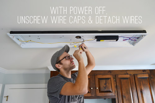 John disconnecting wires in fluorescent light in kitchen