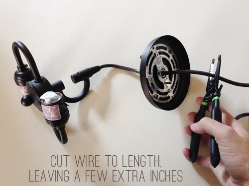 Hand cutting wires on dark pendant light fixture cord