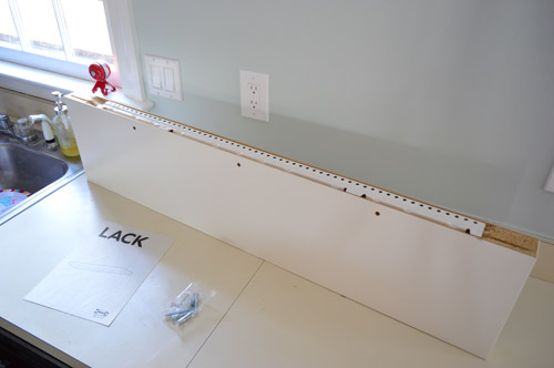 Long LACK floating shelf ready to be hung in kitchen with hanging hardware rail shown