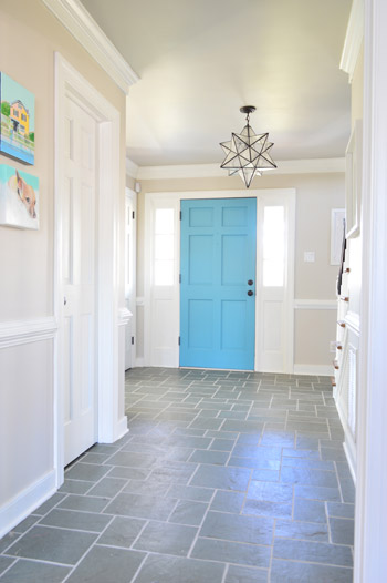 slate tile floor foyer with clean white grout and colorful blue door