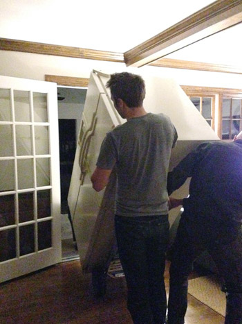 rolling refrigerator through backdoor of house