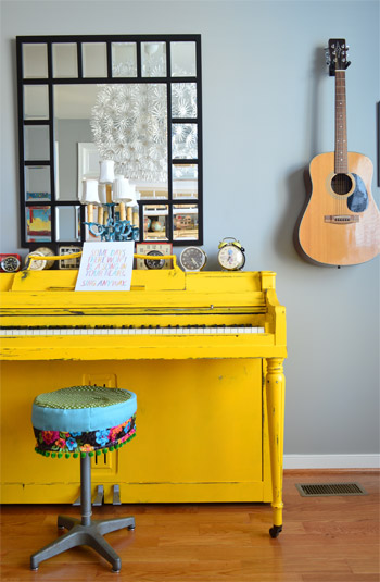 Bright Yellow Painted Piano in Music Room With Guitar On Wall
