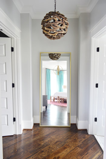 Vestibule Near Closet Of Modern Show House With Driftwood Chandelier And Large Floor Mirror