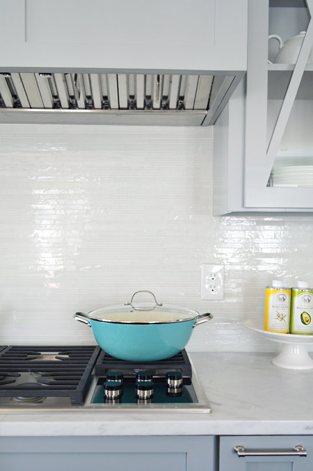 Modern Backplash Detail Over Stovetop With Colorful Cookware