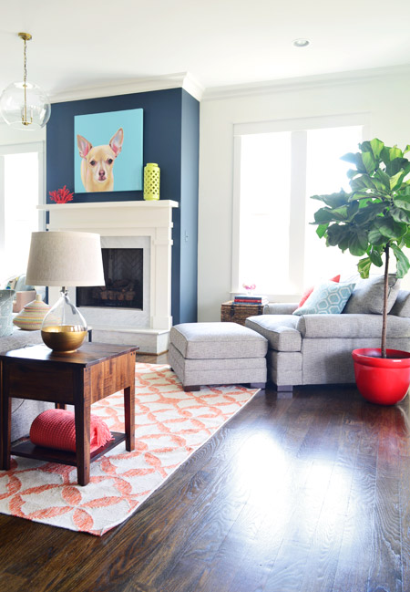 Modern Living Room With Orange West Elm Rug And Chihuahua Painting Over Blue Fireplace