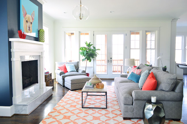 Living Room With Blue Modern Fireplace Column | Orange Rug | Chihuahua Painting