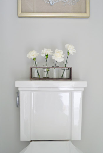 Detail Of Faux Flowers On Top Of Toilet Tank In Modern Show House Bathroom