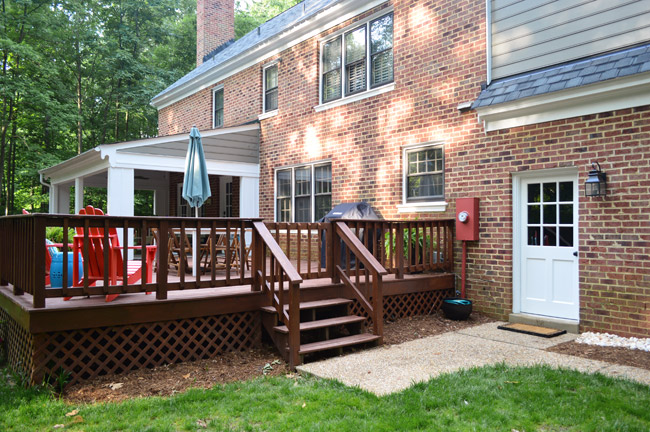 View Of Brick House Backyard With Refreshed Garage Door Area