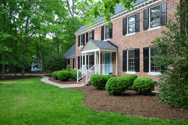 Traditional Brick Colonial Home With Large Boxwood Mulch Beds