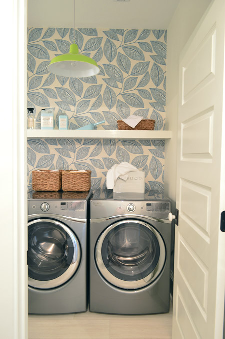 Laundry Room With Dark Cabinets and Large Leafy Wallpaper Print And Green Farmhouse Light