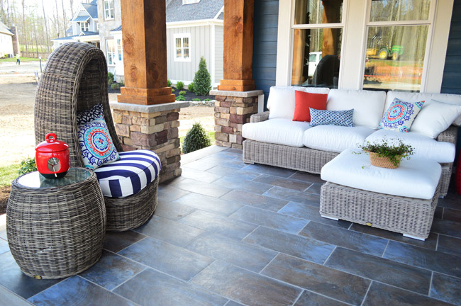 Tiled Front Porch With Outdoor Lounge Sofa And Wicker Egg Chair