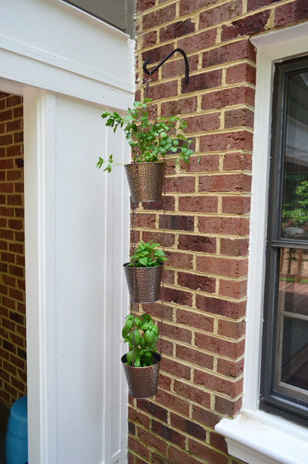 Herb Pots Hanging From Hook On Brick Wall Off House